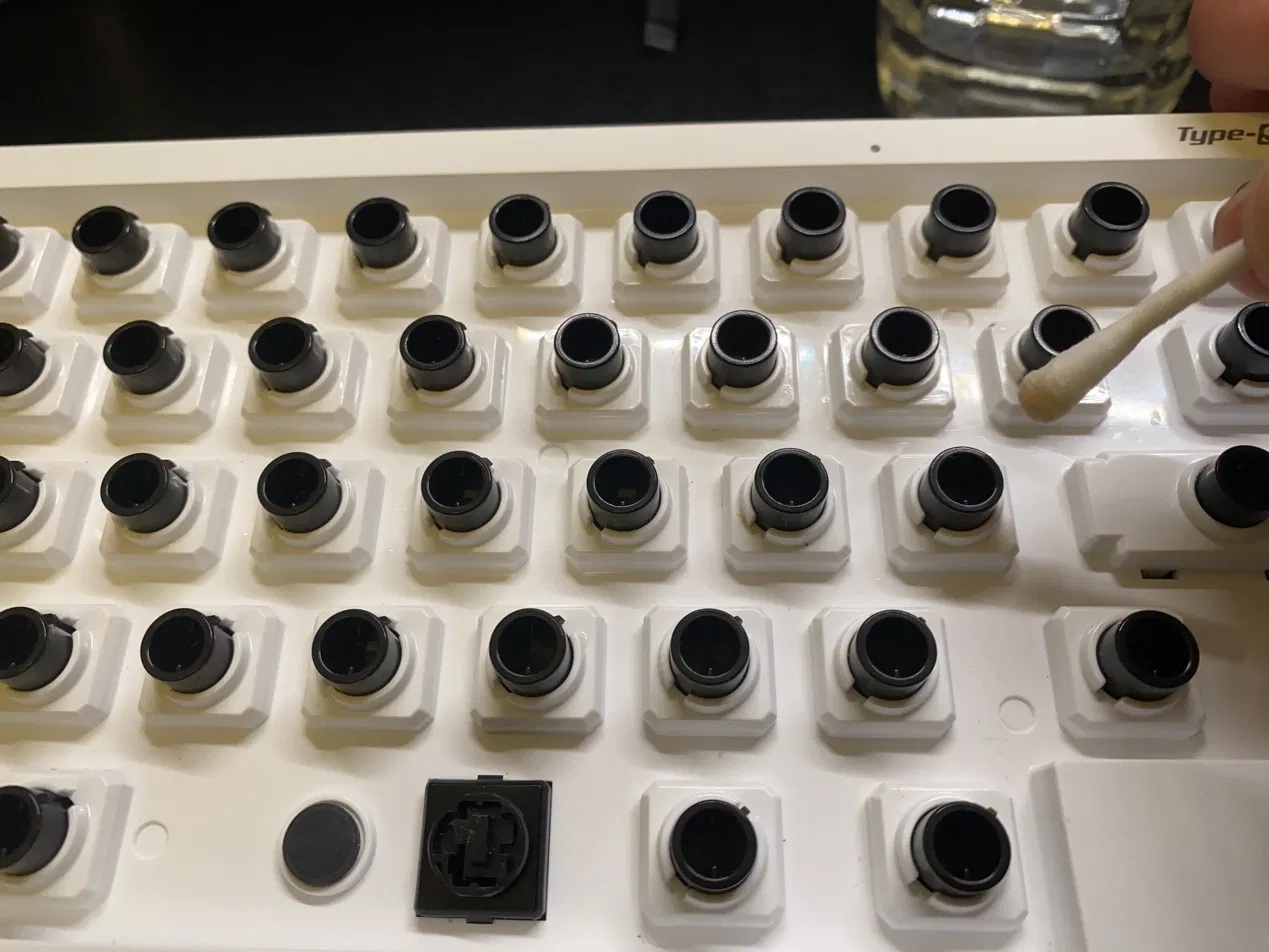 水を含ませた綿棒でHHKBの筐体のコーヒー跡を拭き取る作業
