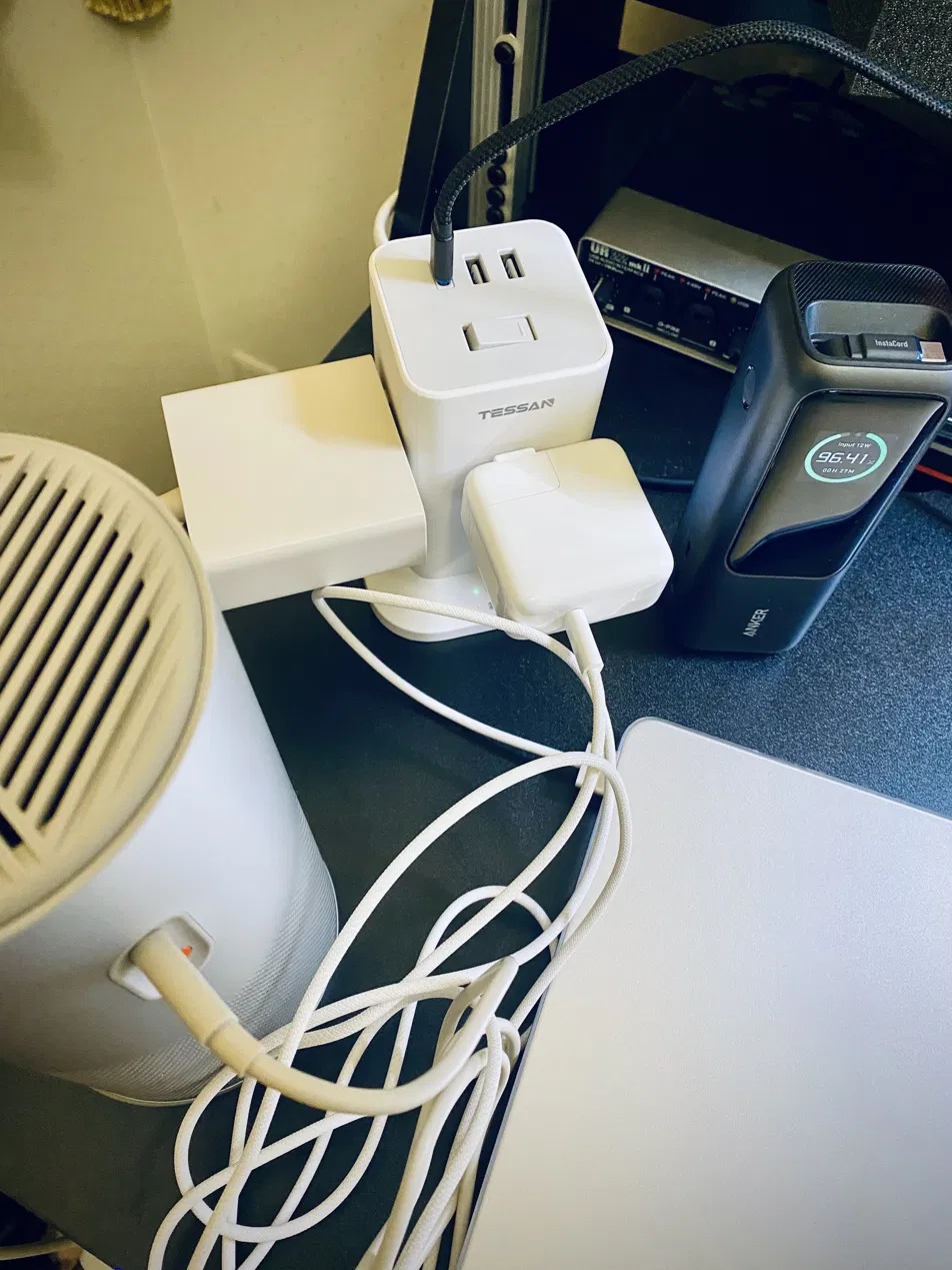 DTMデスクでMacBook Airとモバイルバッテリーを充電中のタワー型電源タップ